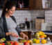 Smiling young pregnant woman preparing healthy food at home